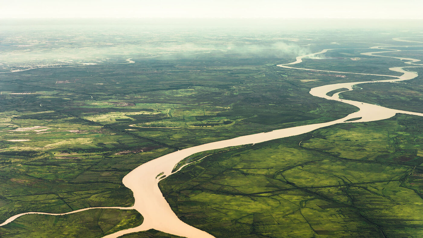 Aerial view of golden Amazon rivers winding through green rainforest, the waterways Indigenous territories depend on