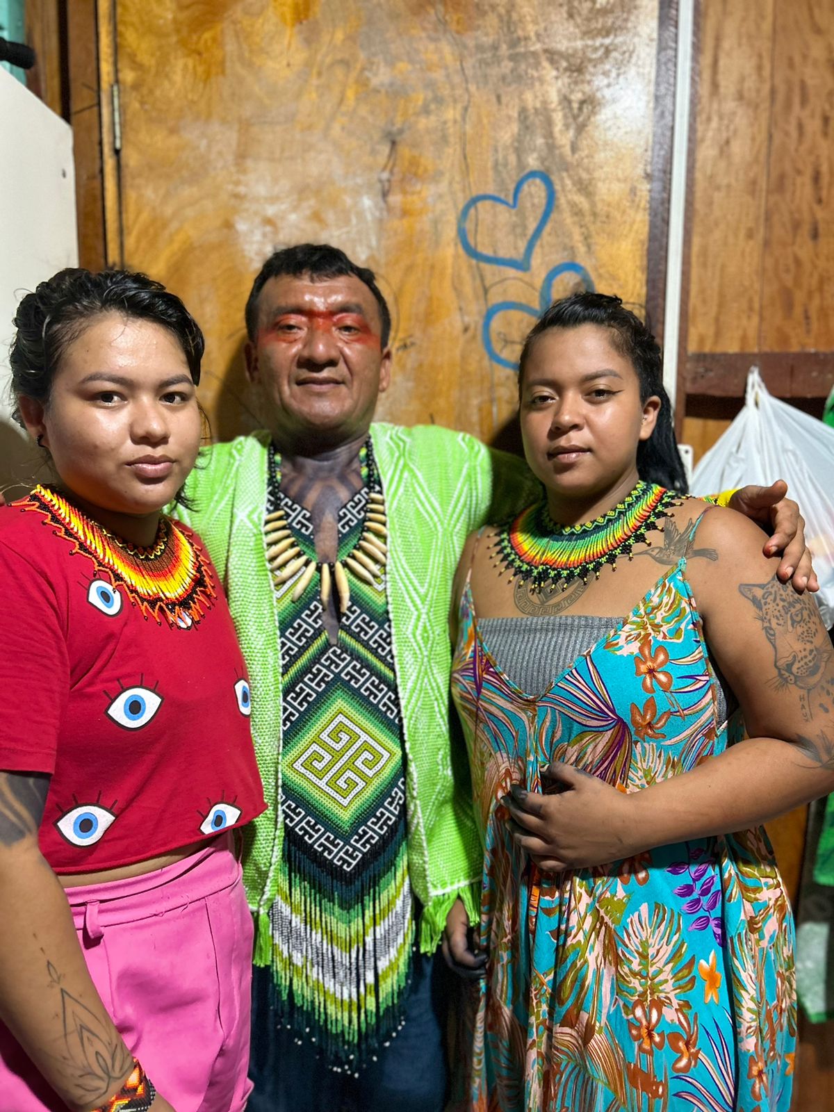 Txai Assis Kaxinawá with his daughters wearing traditional beadwork