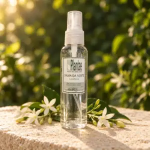 Lady of the Night cologne spray bottle with white blossoms in warm forest light